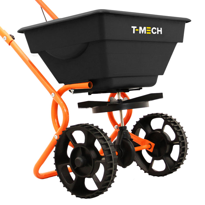 Schwarzer Streuwagen mit orangefarbenem Gestell, großen Gummirädern und einem verstellbaren Auswurfmechanismus für gleichmäßiges Streuen von Düngemitteln