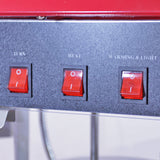 Drei rote Schalter auf einer schwarzen Oberfläche der KuKoo Retro Popcornmaschine, beschriftet mit TURN, HEAT und WARMING & LIGHT, glänzende Textur