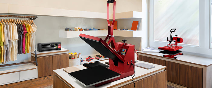 Roter Wärmeübertragungsdrucker auf einem Tisch in einem modernen Raum mit Holzregalen, umgeben von bunten T-Shirts und Druckmaterialien