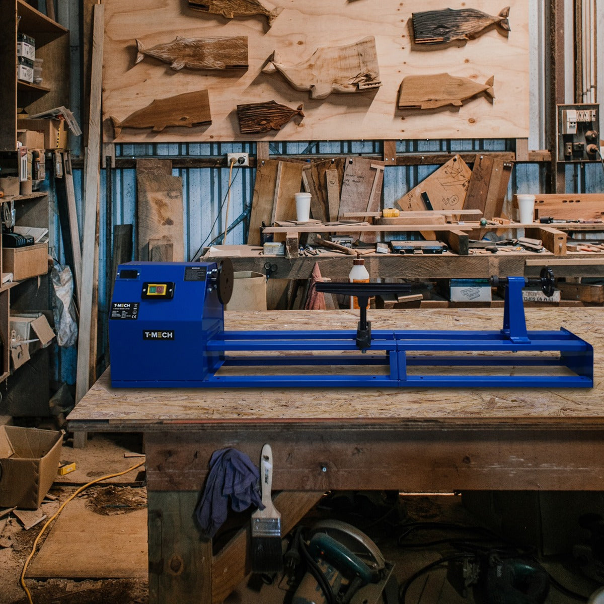 Blau lackierte T-Mech Drechselbank auf einer Holzwerkbank, umgeben von Holzstücken und Werkzeugen in einer Werkstatt, ideal für Holzverarbeitung