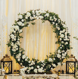 Eleganter Hochzeit Ballonbogen in Gold, umgeben von weißen Blumen und grünem Laub, mit stilvollen Laternen auf dem Boden, ideal für festliche Anlässe